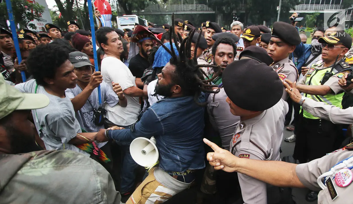 Massa yang tergabung dalam Front Rakyat Indonesia untuk West Papua (FRI-WP) dan Aliansi Mahasiswa Papua (AMP) terlibat aksi saling dorong dengan polisi saat unjuk rasa di Jalan Medan Merdeka Barat, Jakarta, Selasa (15/8). (Liputan6.com/Immanuel Antonius)