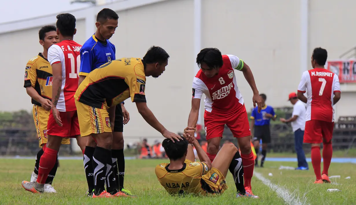 Syamsul Bachri Chaeruddin membantu berdiri pemain Mitra Kukar, Mahdi Fakhri Akbar, dalam partai perempatfinal Piala Presiden 2015 antara Mitra Kukar melawan PSM di Stadion Aji Imbut, Tenggarong, Sabtu (19/9/2015). (Bola.com/M. Ridwan)