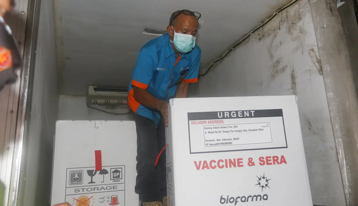Seorang pekerja mendorong kotak berisi vaksin virus corona COVID-19 setibanya di Bali, Selasa (5/1/2021). Provinsi Bali telah mendapatkan 31.000 dosis vaksin virus corona COVID-19 untuk tahap pertama. (AP Photo/Firdia Lisnawati)
