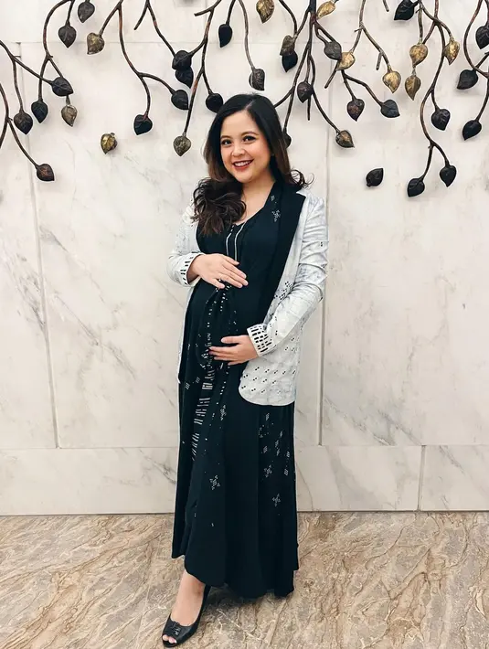 Tampil nyaman dan chic dengan maxi dress hitam yang dipadukan dengan outerwear abu-abu. [IG Tasya Kamila]