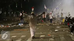 Seorang pendemo berusaha menghalangi kawannya menyerang polisi saat bentrok di Jakarta, Jumat (4/11). Diduga bentrok terjadi saat massa HMI menyerang polisi dan polisi membalasnya dengan melempar gas air mata. (Liputan6.com/Gempur M Surya)