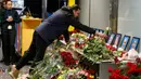 Kerabat salah satu kru pesawat 737-800 Ukraina yang jatuh di Iran, meletakkan bunga pada peringatan di bandara internasional Borispil, Kiev, Rabu (8/1/2020). Pesawat yang membawa 176 orang itu jatuh setelah lepas landas dari bandara utama Teheran dan menewaskan semua penumpang. (AP/Efrem Lukatsky)