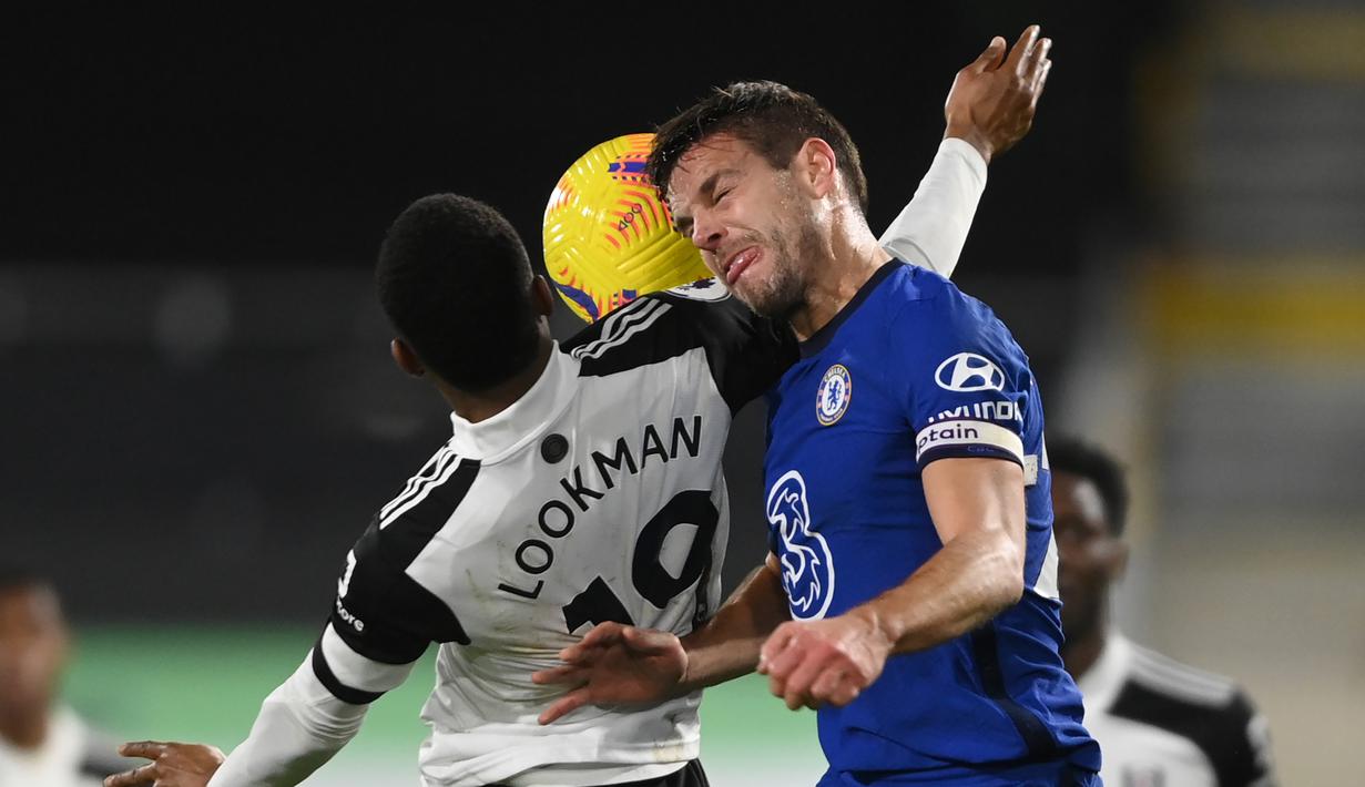 Bek Chelsea, Cesar Azpilicueta (kanan) berduel udara dengan striker Fulham, Ademola Lookman dalam laga lanjutan Liga Inggris 2020/21 pekan ke-18 di Craven Cottage, Sabtu (16/1/2021). Chelsea menang 1-0 atas Fulham. (AFP/Mike Hewitt/Pool)
