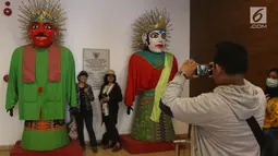 Pengunjung berpose di samping ondel-ondel yang ada di Museum Fatahillah dan Museum Wayang, Kota Tua, Jakarta, Selasa (26/6). Pemprov DKI menggratiskan biaya masuk sejumlah museum pada hari ini. (Liputan6.com/Arya Manggala)