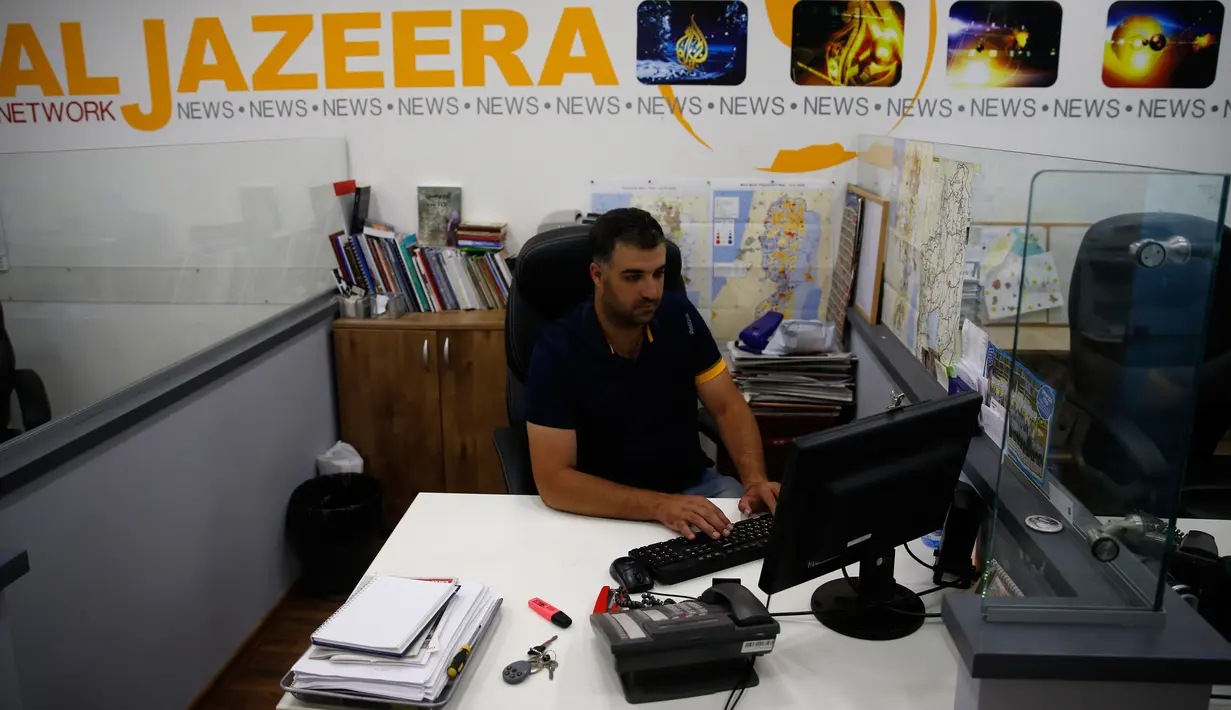 Seorang karyawan berada di balik mejanya di kantor berita Al Jazeera, Yerusalem, 31 Juli 2017. Israel menuduh Al Jazeera mendukung terorisme, dan menyebutkan bahwa saluran bahasa Arab dan bahasa Inggrisnya akan diblokir. (AHMAD GHARABLI/AFP)