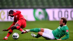 Pemain Werder Bremen Philipp Bargfrede (kanan) berebut bola dengan pemain Bayer Leverkusen Moussa Diaby dalam pertandingan Bundesliga di Bremen, Jerman, Senin (18/5/2020). Bayer Leverkusen menang 4-1. (Stuart FRANKLIN/POOL/AFP)