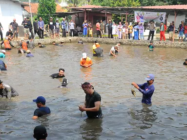 Warga menangkap ikan dengan tangan kosong saat acara Ngubek Empang di kawasan Bojongsari, Depok, Jawa Barat, Senin (15/5/2023). Kegiatan ini merupakan rangkaian Lebaran Depok Jilid 5. (merdeka.com/Arie Basuki)