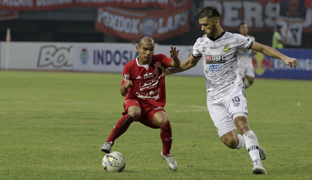 Gelandang Persija Jakarta, Riko Simanjutak, berebut bola dengan bek Tira Persikabo, Khurshed Beknazarov, pada laga Shopee Liga 1 di Stadion Patriot Chandrabhaga, Bekasi, Minggu (3/11). Persija menang 2-0 atas Tira Persikabo. (Bola.com/Yoppy Renato)