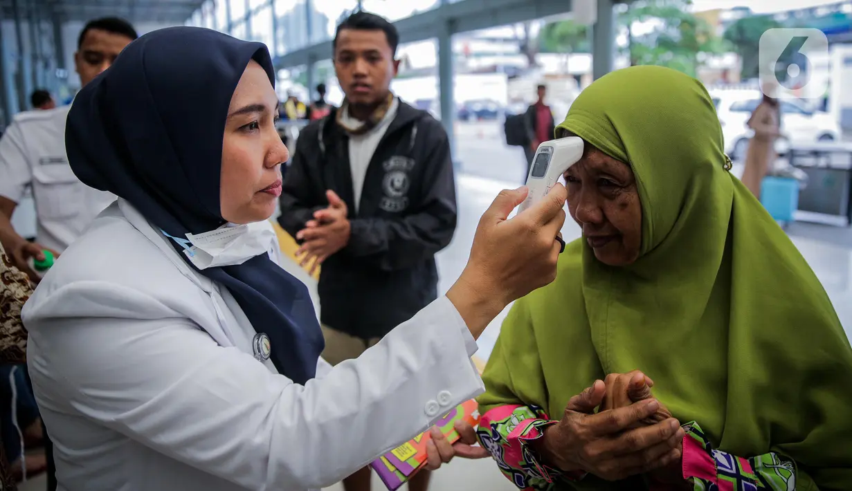 Petugas mengecek suhu tubuh calon penumpang di Stasiun Senen, Jakarta, Senin (9/3/2020). PT KAI Daop 1 Jakarta melakukan sosialisasi pencegahan, pemeriksaan kesehatan, dan pengecekan suhu tubuh penumpang sebagai langkah antisipasi penyebaran virus corona (COVID-19). (Liputan6.com/Faizal Fanani)