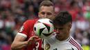 Bek Timnas Hungaria, Milos Kerkez (depan) berebut bola dengan bek Timnas Swiss, Silvan Widmer pada laga Grup A Euro 2024 di RheinEnergie Stadium, Cologne, Jerman, Sabtu (15/6/2024). (AP Photo/Darko Vojinovic)