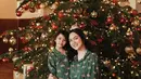 Shandy Aulia dan putrinya merayakan Natal dengan outfit kompak berfoto di depan pohon Natal besar. Keduanya mengenakan piyama hijau. [@shandyaulia]