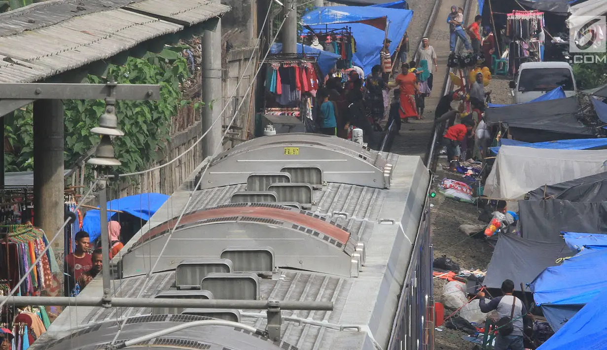 Warga Gunung Putri melakukan aktivitas jual beli di pasar dadakan yang berada di sisi rel KRL Nambo, Citeureup, Bogor (20/4). Meskipun berbahaya para pedagang tetap menjajakan dagangannya di tempat tersebut. (Merdeka.com/Arie Basuki)