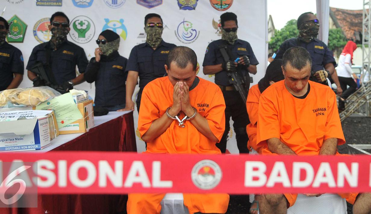 Tersangka dihadirkan saat pemusnahan barang bukti narkotik jenis shabu sebanyak 120 kilogram di lapangan parkir Kota Tua, Jakarta, Jumat (26/2). Barang bukti narkoba didapat BNN dari hasil tangkapan sejak awal Januari 2016. (Liputan6.com/Gempur M Surya)