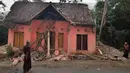 Warga melihat rumah yang rusak usai gempa melanda Pandeglang, Banten, Sabtu (3/8/2019). Menurut data sementara BPBD, sebanyak 106 unit rumah di Kabupaten Pandeglang dan Lebak rusak usai gempa Banten berkekuatan magnitudo 6,9. (RONALD SIAGIAN/AFP)
