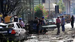 Warga dan petugas saat memeriksa kerusakan yang terjadi di Bank Blom pasca ledakan di Beirut, Lebanon (13/6).Bom tersebut menghancurkan gedung, fasilitas dan kendaraan yang terparkir dekat gedung. (REUTERS/Jamal Saidi)
