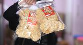 Pekerja menunjukkan salah satu hasil produksi pembuatan keripik tempe di rumah usaha Keripik Tempe Mama Tina, Kebayoran Baru, Jakarta Selatan, Kamis (7/5/2026). Keripik Tempe Mama Tina merupakan usaha rumahan memproduksi keripik tempe dengan beragam varian rasa seperti original bawang putih, balado, barbeque, hingga sapi panggang. (merdeka.com/Arie Basuki)