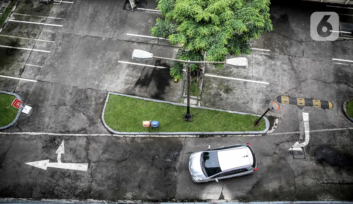 Sebuah mobil melintas di lahan parkir yang sepi di sebuah gedung, Jakarta, Kamis (1/5/2020). Indonesia Parking Association (IPA) menyatakan terjadi penurunan bisnis parkir sebesar 75-90 persen seiring penerapan PSBB untuk mencegah penyebaran COVID-19 di Jabodetabek. (Liputan6.com/Faizal Fanani)