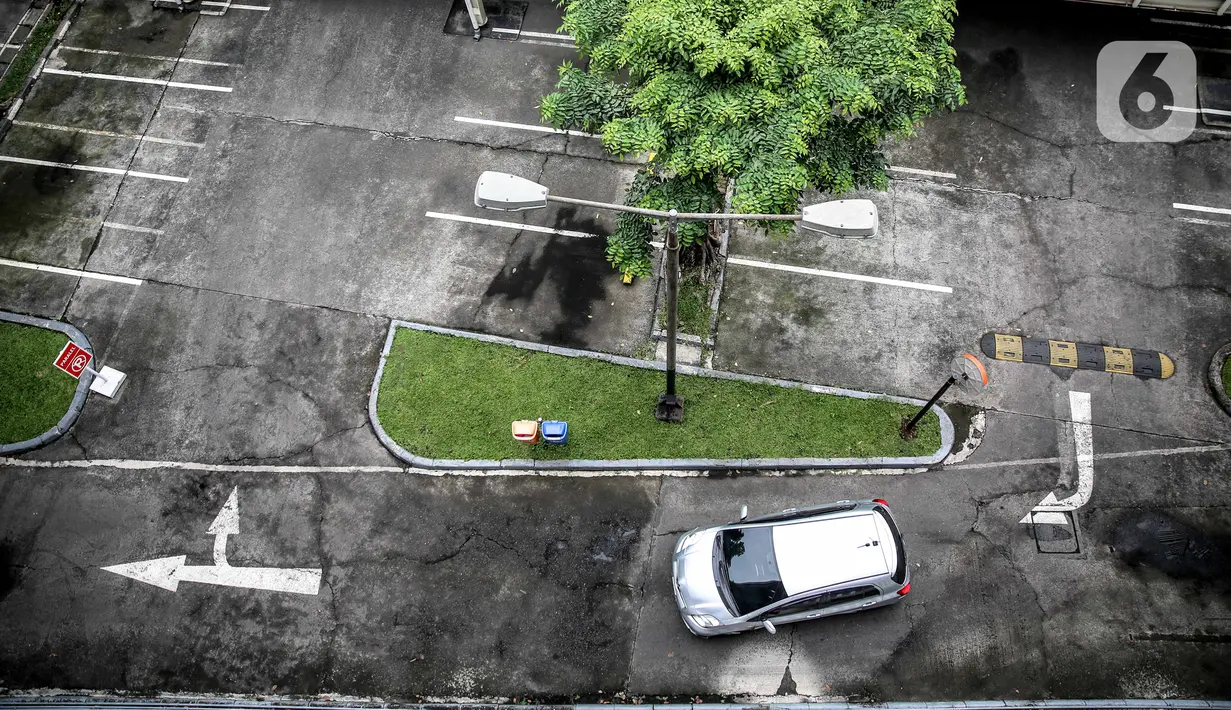 Sebuah mobil melintas di lahan parkir yang sepi di sebuah gedung, Jakarta, Kamis (1/5/2020). Indonesia Parking Association (IPA) menyatakan terjadi penurunan bisnis parkir sebesar 75-90 persen seiring penerapan PSBB untuk mencegah penyebaran COVID-19 di Jabodetabek. (Liputan6.com/Faizal Fanani)