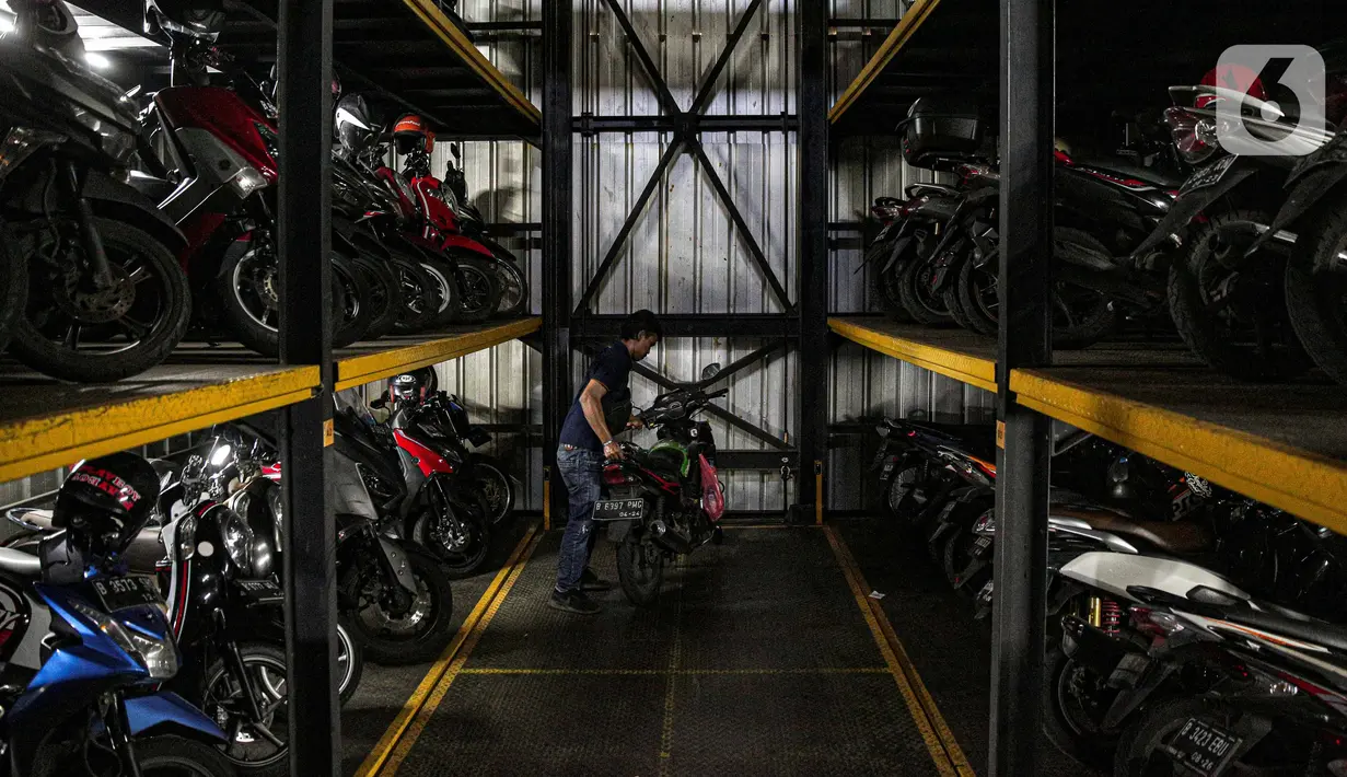 Pelanggan bersiap memarkirkan kendaraanya di Soul Parking, Kebon Kacang, Jakarta, Senin (24/1/2022). Tempat parkir vertikal tersebut bisa menyimpan lebih banyak motor di atas lahan sempit. (Liputan6.com/Faizal Fanani)