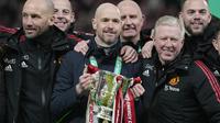 Pelatih Manchester United atau MU Erik ten Hag dan anggota tim berpose dengan trofi juara Carabao Cup 2022/2023 usai kalahkan Newcastle United pada partai final di Stadion Wembley, Senin dini hari WIB (27/2/2023). Ini adalah gelar pertama buat sang manajer Setan Merah Erik ten Hag. (AP Photo/Alastair Grant)