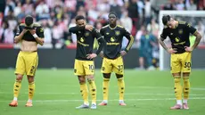 Para pemain Manchester United tampak kecewa setelah ditaklukkan Brentford 1-3 pada pertandingan pekan keenam Liga Inggris 2025/2026 di Gtech Community Stadium, Sabtu (27/09/2025). (AFP/Justin Tallis)