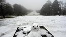 Anak-anak bermain (kiri) di dalam lapangan golf yang tertutup salju pertama musim ini di Katoomba di Blue Mountains (10/6/2021). (AFP/Saeed KHAN)