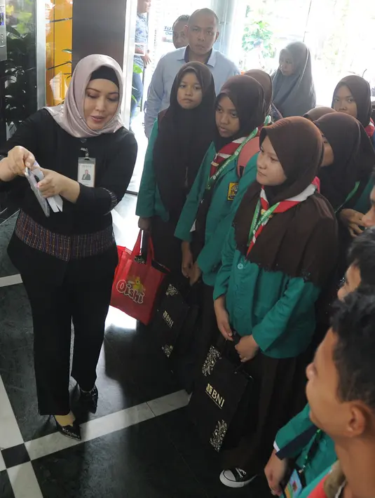 Karyawan BNI memberi pengetahuan tentang perbankan kepada para siswa saat berkunjung ke BNI Kantor Cabang Tebet, Jakarta (2/5). (Merdeka.com/Arie Basuki)