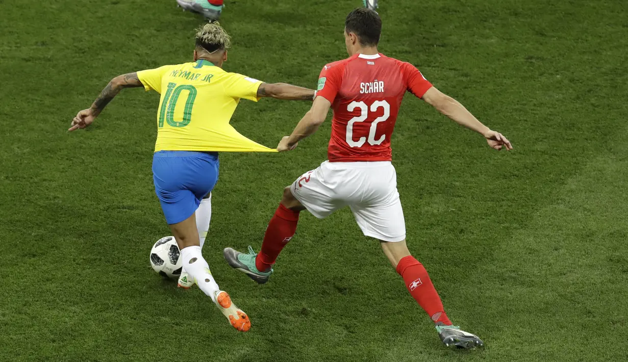 Striker Brasil, Neymar, berusaha melewati pemain Swiss, Fabian Schaer, pada laga Piala Dunia di Stadion Rostov, Rusia, Senin (17/6/2018). Dilanggar sebanyak 10 kali membuat Neymar masuk rekor di Piala Dunia. (AP/Andrew Medichini)