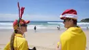 Penyelamat selancar Summer Robinson, kiri, dan Lachlan Sharp mengawasi para wisatawan yang sedang berlibur di Pantai Bondi di Sydney, Senin, 25 Desember 2023. (AP Photo/Rick Rycroft)