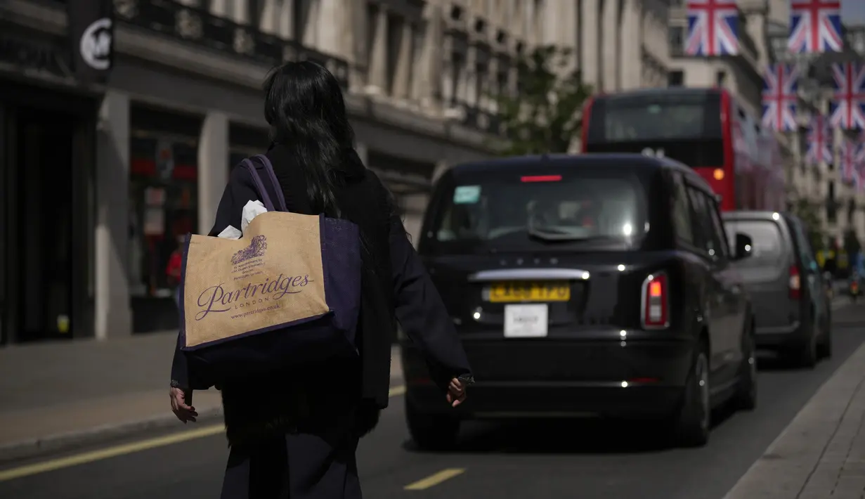 <p>Seorang perempuan membawa tas belanja yang dapat digunakan kembali melintasi distrik perbelanjaan Regent Street, di London, Rabu (18/5/2022). Kantor Stastitik Nasional (ONS) Inggris mengatakan inflasi indeks harga konsumen meningkat menjadi 9% dalam 12 bulan hingga April, dari 7% pada bulan Maret. (AP Photo/Matt Dunham)</p>