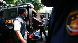 Petugas kepolisian memasukkan barang bukti hasil penggeledahan dari rumah di Sentul terkait dugaan kasus korupsi ke dalam gedung Direktorat Reserse Kriminal Khusus (Disreskrimsus) Polda Metro Jaya, Kamis (9/7/2026), (KLY/Budy Santoso)