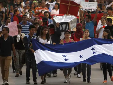 Ribuan demonstran turun ke jalan menuntut pengunduran diri Presiden Honduras, Juan Orlando Hernandez di Tegucigalpa, Jumat (24/7/2015).  Massa menuntut Presiden Juan Hernandez turun atas dugaan korupsi. (REUTERS/Jorge Cabrera)