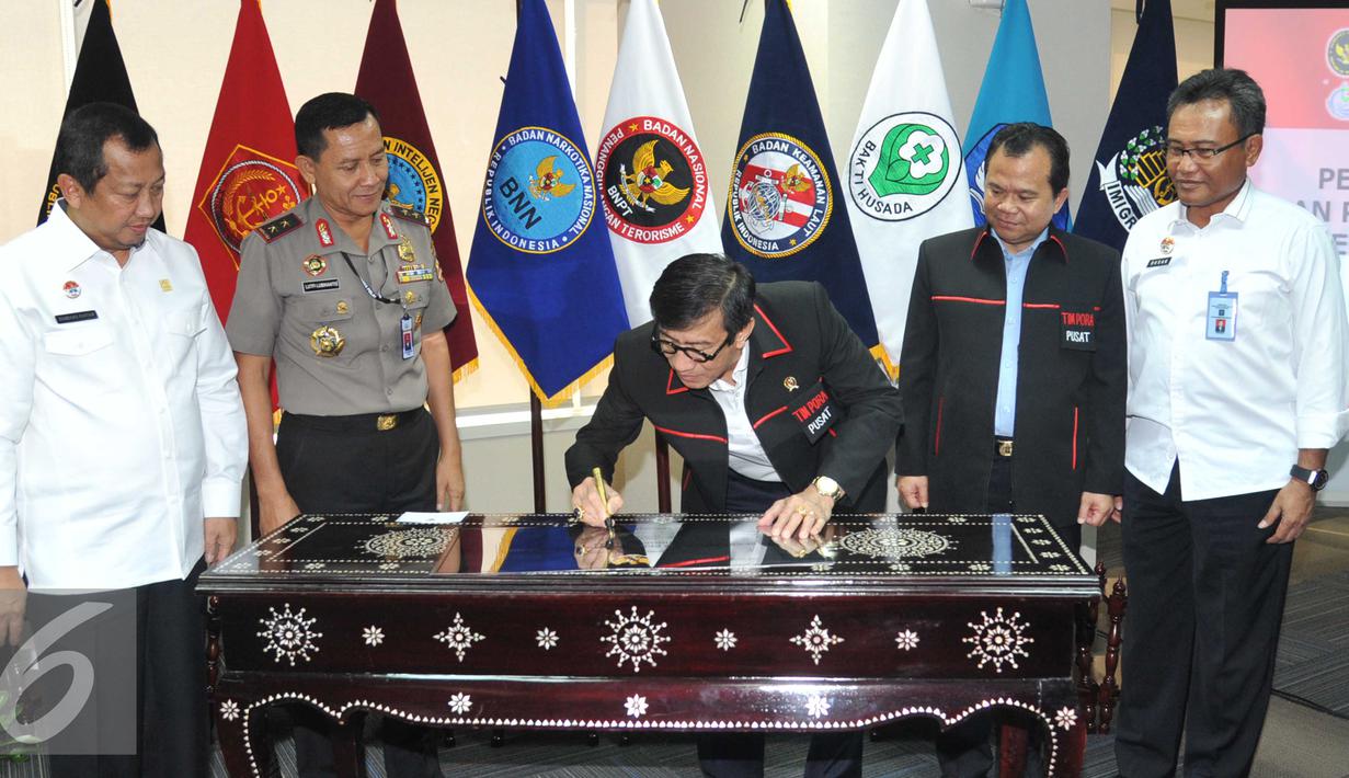 Menkumham Yasonna Laoly menandatangani prasasti saat meresmikan tim Pengawasan Orang Asing  (PORA) di Gedung Imigrasi Kemenkumham, Jakarta (8/4). Yasonna berharap tim PORA dapat mencegah kejahatan transnasional. (Liputan.com/Helmi Afandi)