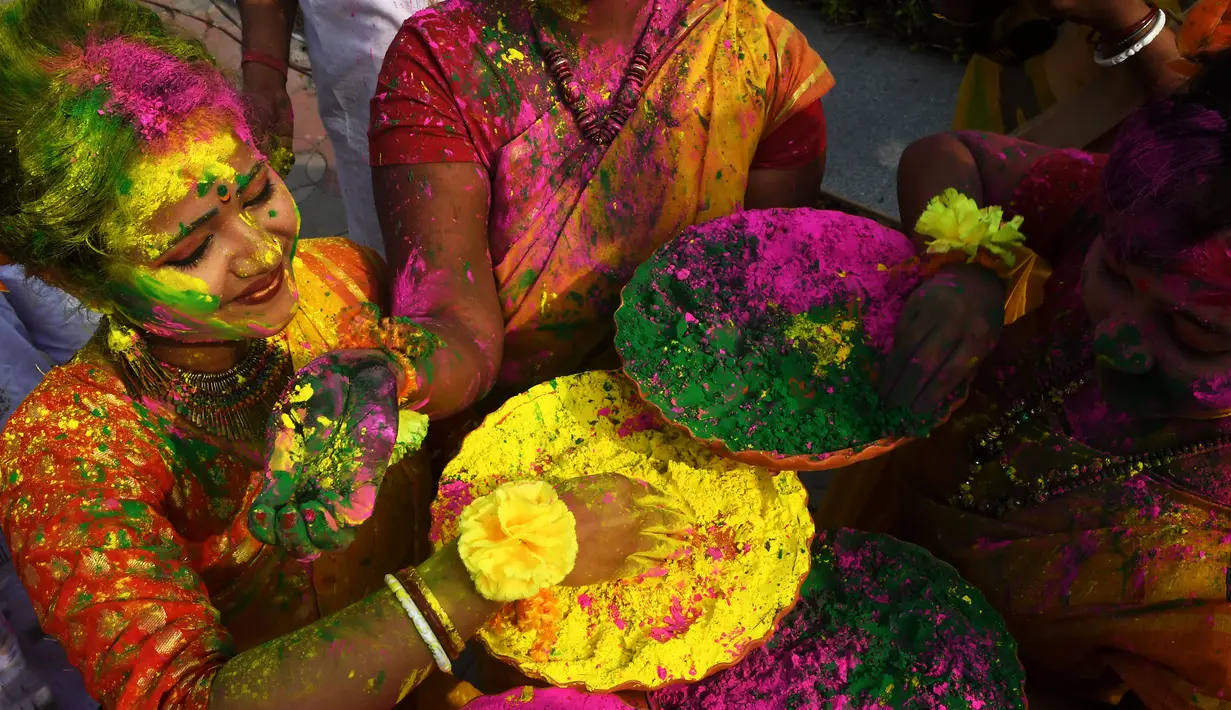 Warga bermain dengan tepung berwarna-warni untuk merayakan Festival Holi di Kolkata, India, Kamis (1/3). Festival ini juga mendatangi datangnya musim semi. (Dibyangshu SARKAR/AFP)
