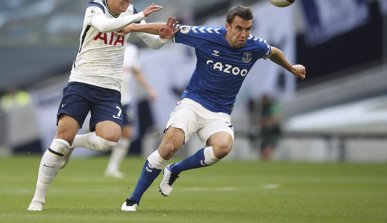 Penyerang Tottenham Hotspur, Son Heung-min berebut bola dengan pemain Everton, Seamus Coleman pada pertandinga Liga Inggris di i Stadion Tottenham Hotspur di London, Minggu, (13/9/2020). Everton menang 1-0 atas Totttenham. (Alex Pantling/Pool via AP)