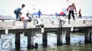 Warga dan petugas TNI AL menolong anak kecil yang terjatuh ke laut di dermaga Muara Angke, Jakarta, Kamis (24/3). Akibat kelalaian ibunya seorang anak tercebur ke laut dan langsung di selamatkan warga dan prajurit TNI AL. (Liputan6.com/Faizal Fanani)