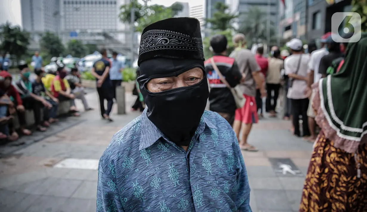 Warga antre makanan gratis di kawasan Sudirman, Jakarta, Jumat (8/5/2020). Bagi-bagi makanan ini dilakukan sebagai bentuk kepedulian untuk pengemudi ojol dan warga sekitar yang terdampak kebijakan penanganan virus corona, seperti work frome home dan physical distancing. (Liputan6.com/Faizal Fanani)