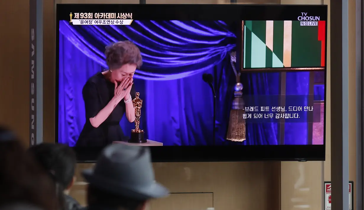 Orang-orang menonton siaran langsung TV yang menunjukkan aktris Korea Selatan Yuh-Jung Youn menerima Piala Oscar untuk Aktris Pendukung Terbaik dalam film Minari di Stasiun Kereta Seoul di Seoul, Senin (26/4/2021). (AP Photo/Lee Jin-man)