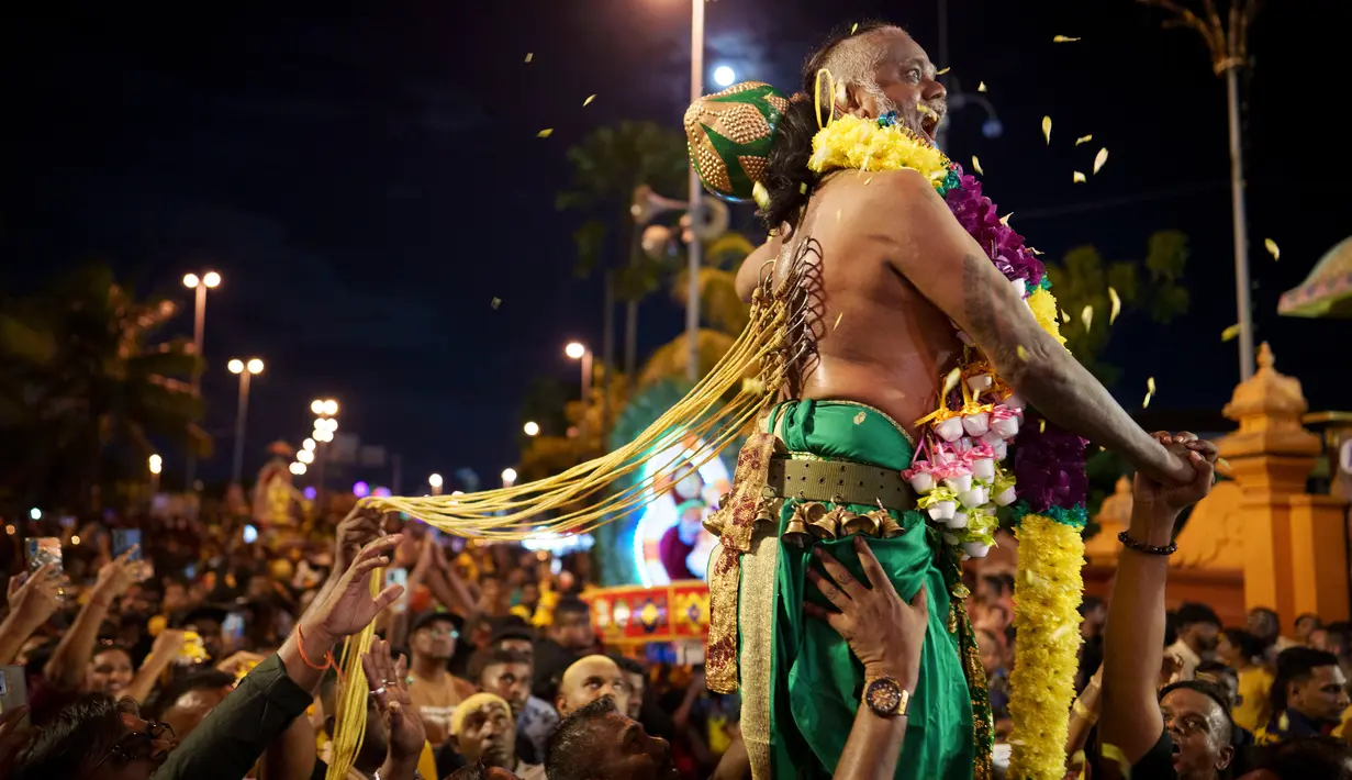 Umat Hindu mengikuti prosesi saat mereka berjalan dalam Kuil Sri Subramaniyar pada perayaan Thaipusam di Batu Caves, Kuala Lumpur, Malaysia, Minggu (5/2/2023). Thaipusam, yang dirayakan untuk menghormati Dewa Murugan, adalah acara tahunan umat Hindu untuk mencari berkah, memenuhi sumpah, dan mengucapkan terima kasih. (AP Photo/Vincent Thian)