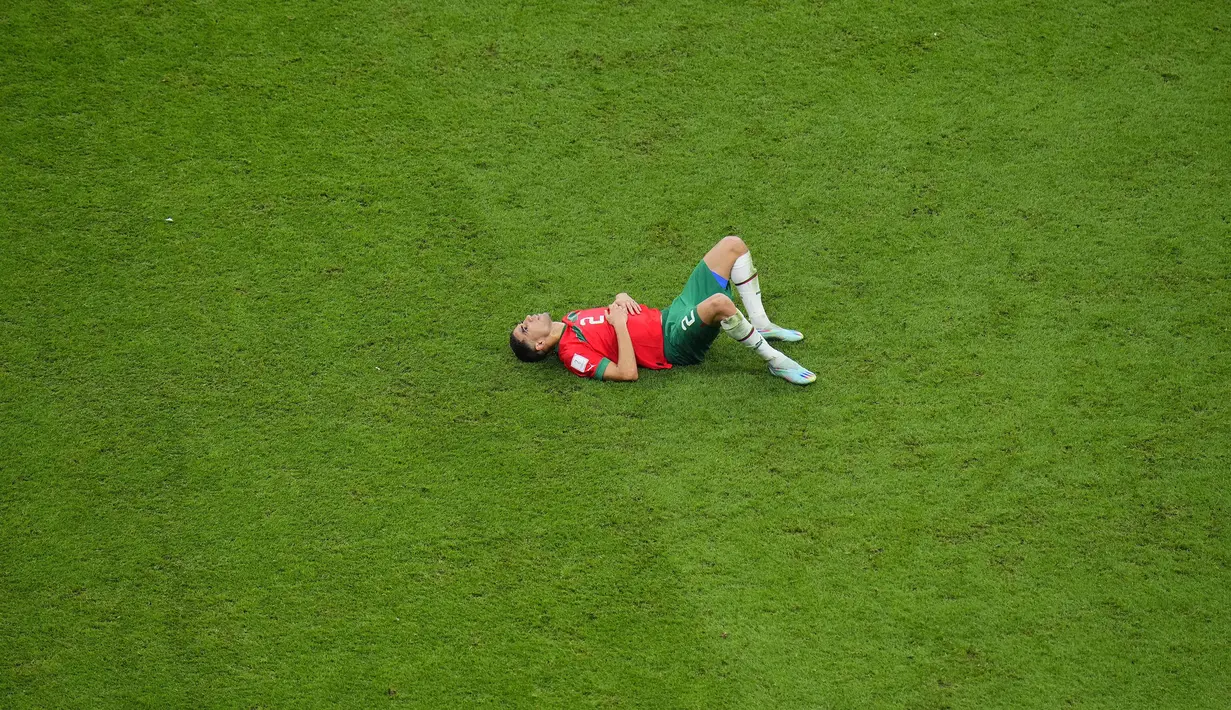 Reaksi kecewa pemain Maroko, Achraf Hakimi setelah kalah dari Prancis pada laga semifinal Piala Dunia 2022 yang berlangsung di Al Bayt Stadium, Qatar, Rabu (14/12/2022) waktu setempat. Prancis menang dengan skor 2-0 melalui gol Theo Hernandez dan Randal Kolo Muani. (AP Photo/Hassan Ammar)