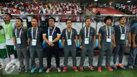 Pelatih Aji Santoso (tengah) bersama official timnas Indonesia U-23 berdiri tegap menyanyikan Indonesia Raya jelang melawan Myanmar di penyisihan grup A Sea Games 2015 di Stadion Jalan Besar, Singapura, Selasa (2/6/2015). (Liputan6.com/Helmi Fithriansyah)