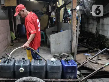 Pedagang mengisi air bersih ke dalam jeriken sebelum menjualnya kepada warga di Kampung Baru Kubur, Penjaringan, Jakarta Utara, Selasa (11/1/2022). Sudah tiga bulan warga RW 15 Kampung Baru Kubur, tepatnya RT 4, 5, 6, dan 7 mengalami krisis air bersih. (merdeka.com/Iqbal S. Nugroho)