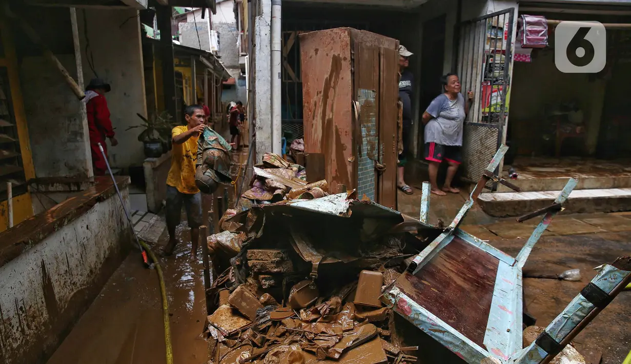 Warga membersihkan sisa lumpur yang tertinggal di permukiman mereka yang ada di sekitar jalan layang Kalibata-Cililitan, Jakarta, Rabu (5/3/2025). (Liputan6.com/Angga Yuniar)
