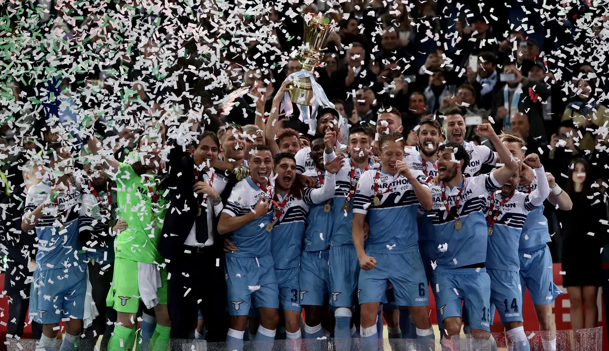 Pelatih Lazio, Simone Inzaghi dan para pemain memegang trofi Coppa Italia pada akhir babak final yang mempertemukan Atalanta dan Lazio di Stadio Olimpico, Roma, Rabu (15/5/2019). Lazio keluar sebagai juara Coppa Italia setelah mengalahkan Atalanta 2-0. (Isabella BONOTTO/AFP)