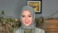 Ia menyempurnakan penampilannya dengan hijab warna hijau sage. Wajahnya pun dipoles dengan makeup natural.