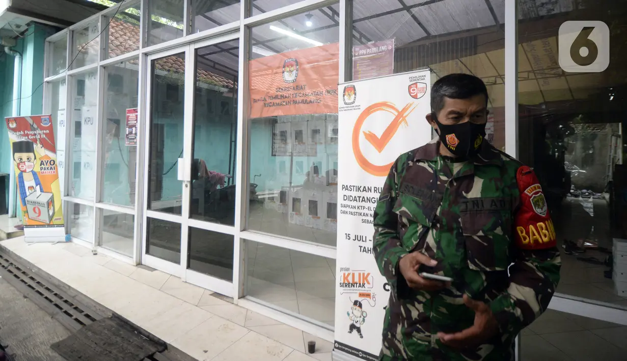 Tentara berdiri menjaga kotak hasil rekapitulasi penghitungan suara di TPS tingkat kelurahan di Kecamatan Pamulang, Tangerang Selatan, Banten, Kamis (10/12/2020). Proses rekapitulasi suara ditunda sementara karena terkendala jaringan ke server KPU Pusat down. (merdeka.com/Dwi Narwoko)