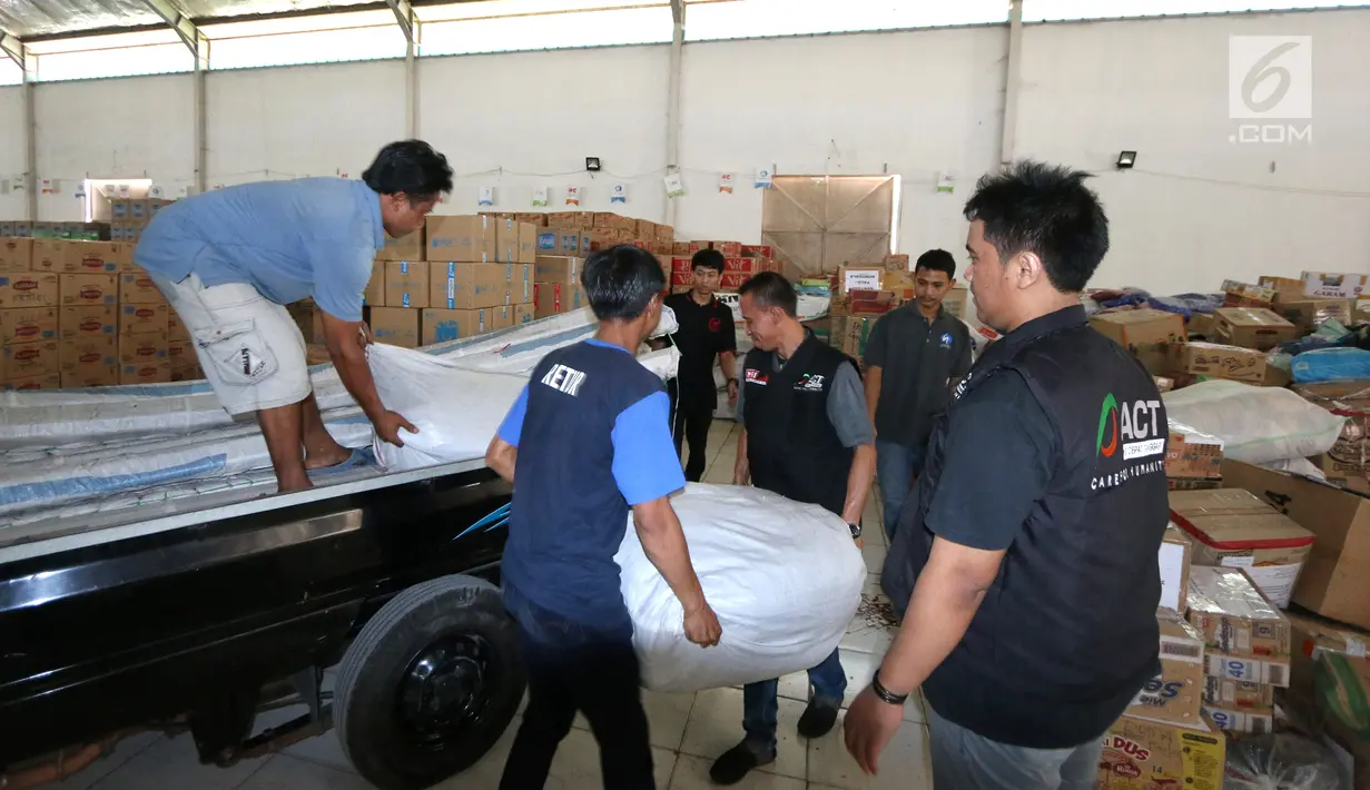 Petugas menurunkan bantuan 4 tenda darurat dan kebutuhan lainnya dari PT Jakarta International Container Terminal (JICT) untuk korban gempa dan tsunami di Palu dan Donggala di Gudang IHC-ACT Parung, Bogor, Jumat (12/10). (Liputan6.com/HO/Arif)