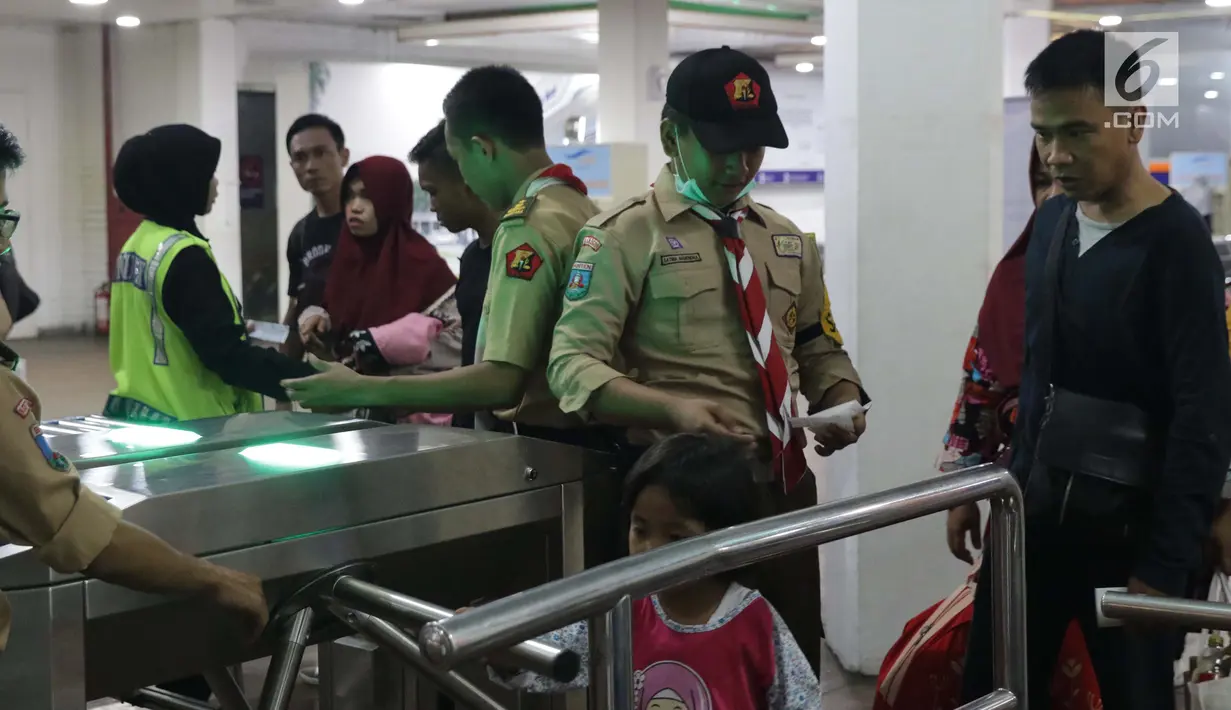 Anggota Pramuka membantu calon penumpang melakukan cek in elektronik di ruang tunggu menuju dermaga Pelabuhan Penyeberangan Merak, Banten, Sabtu (1/6/2019). Hingga Sabtu (1/6) pukul 08.00 WIB, tercatat 400.309 orang menyebrang dari pelabuhan Merak menuju Bakauheni. (Liputan6.com/Helmi Fithriansyah)