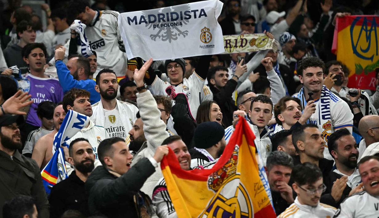 Los Blancos menutup pertandingan dengan agregat meyakinkan 5-1 atas Manchester City. Tampak dalam foto, penggemar Madrid bersorak mendukung tim mereka selama pertandingan leg kedua 16 besar Liga Champions 2025/2026 melawan Manchester City di Etihad Stadium, barat laut Inggris, pada Selasa 17 Maret 2026 waktu setempat atau Rabu (18/3) dini hari WIB. (Paul ELLIS/AFP)
