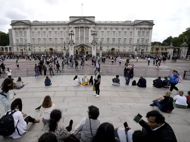 Turis berdiri di depan Istana Buckingham di London, Kamis (8/9/2022). Istana Buckingham mengatakan Ratu Elizabeth II telah ditempatkan di bawah pengawasan medis karena dokter "memperhatikan kesehatan Yang Mulia." Anggota keluarga kerajaan pergi ke Skotlandia untuk bersama raja berusia 96 tahun itu. (AP Photo/Frank Augstein)